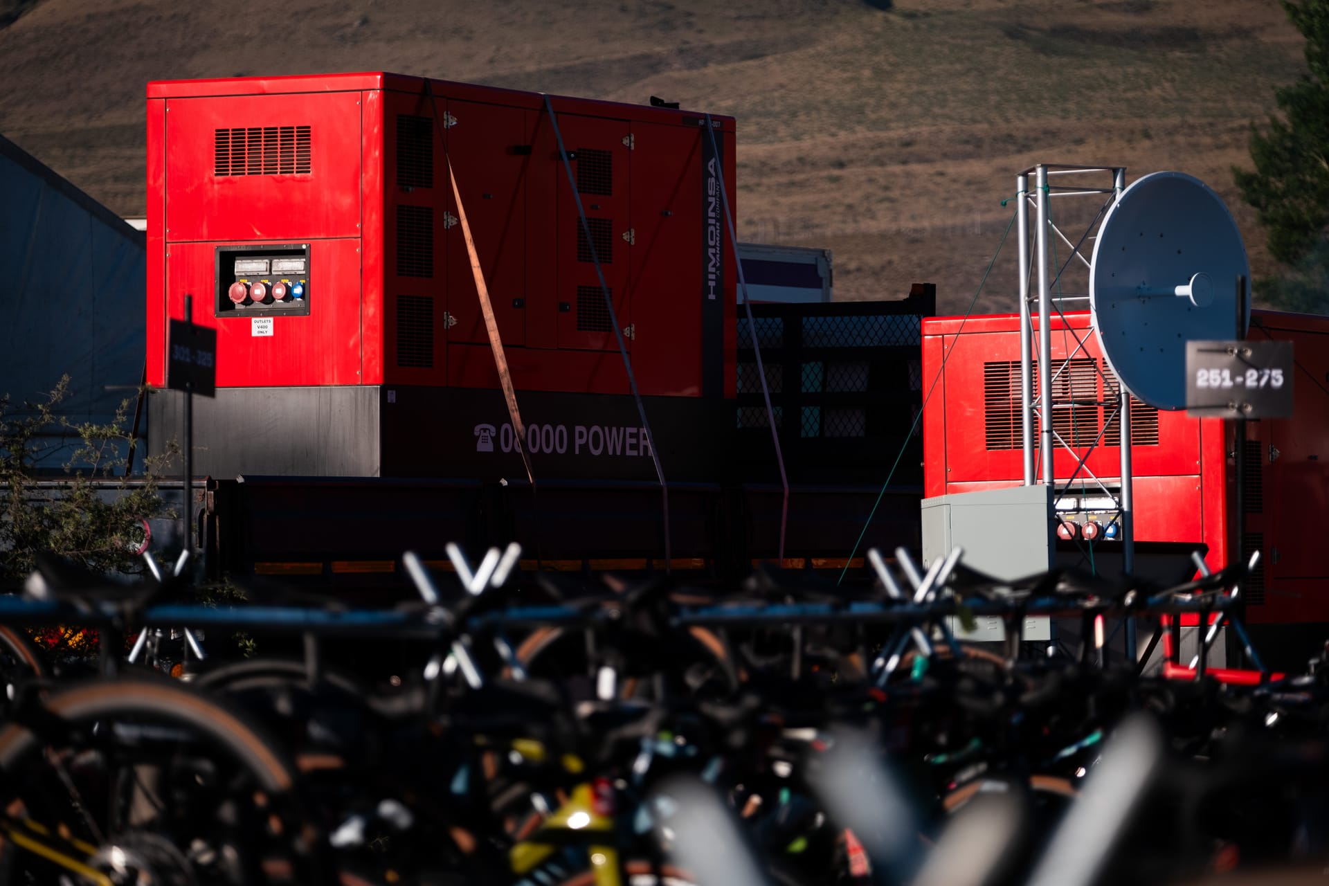 Generators and a satellite dish behind the bikes in a Burn Camp’s Bike Park